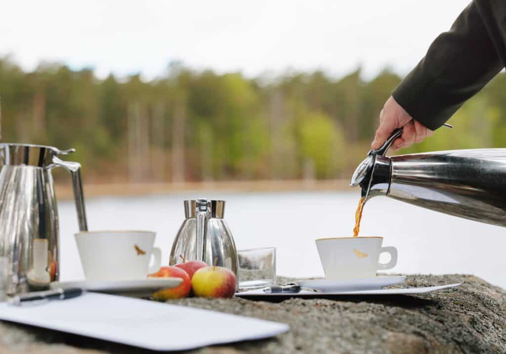 Ontbijt met koffie en appels wordt geserveerd aan het meer bij Eriksberg.