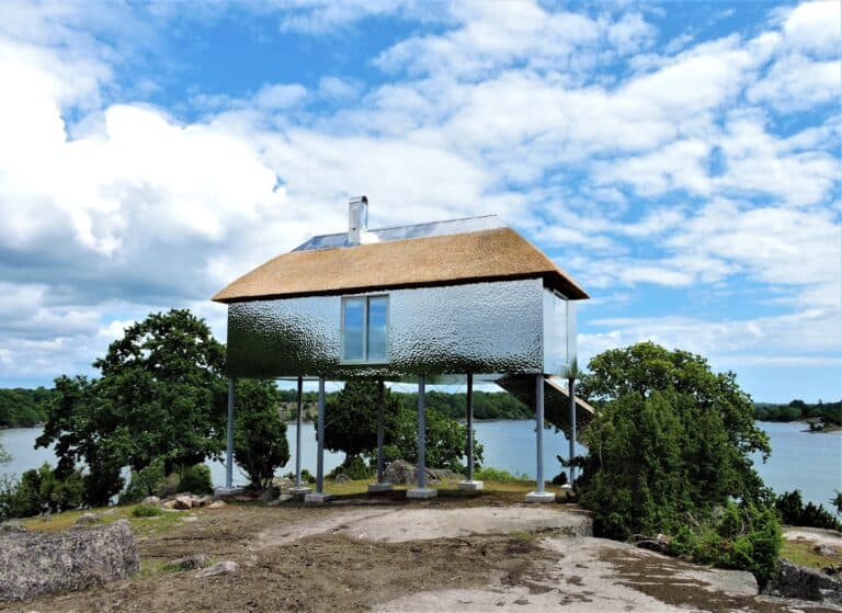 Unikt hus på pålar vid vattnet i Eriksberg med naturskön omgivning.